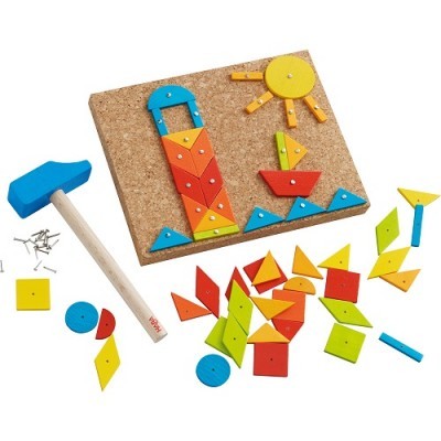 Brinquedo de construção com formas geométricas coloridas e martelo de madeira em base de cortiça.