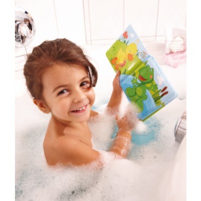 Criança na banheira com espuma a ler um livro infantil de banho colorido