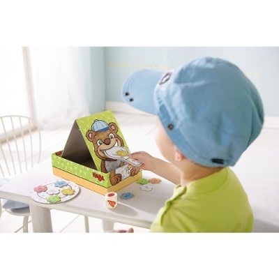 Jogo infantil com tabuleiro de urso e crianças a jogar em mesa branca