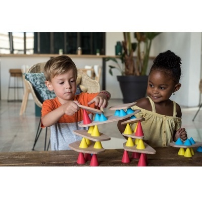 Crianças a jogar com cones coloridos e placas de madeira em ambiente interior