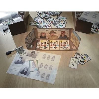 Jogo de tabuleiro com cartas coloridas, personagens ilustrados, caneta branca e folhas com impressões digitais