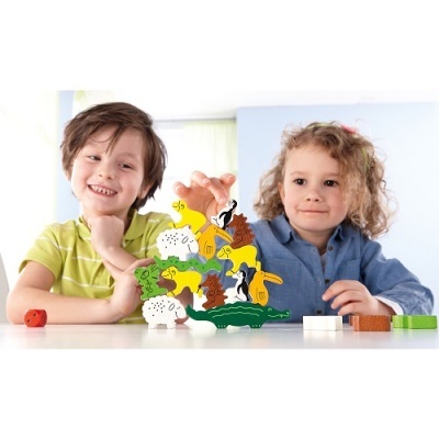 Crianças a brincar com animais de madeira coloridos sobre mesa branca