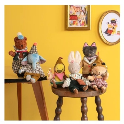 Bonecos de pelúcia de animais com roupas coloridas sobre bancos de madeira