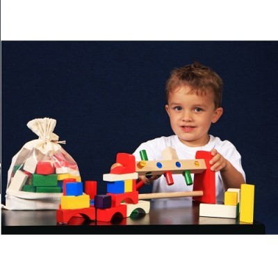 Criança a brincar com brinquedos de madeira coloridos sobre mesa preta