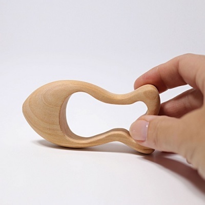 Objeto de madeira clara com formato irregular segurado pela mão