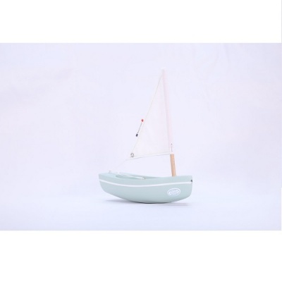 Barco de brinquedo verde claro com vela branca sobre fundo branco