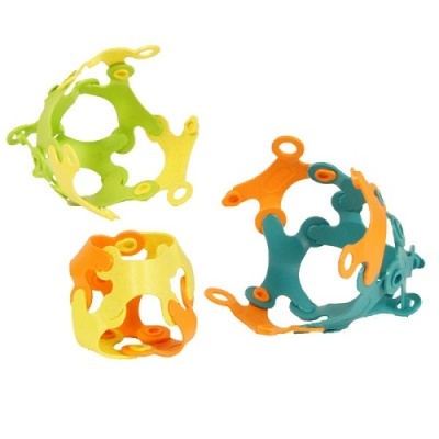 Peças de construção em plástico colorido com orifícios destacadas num fundo branco