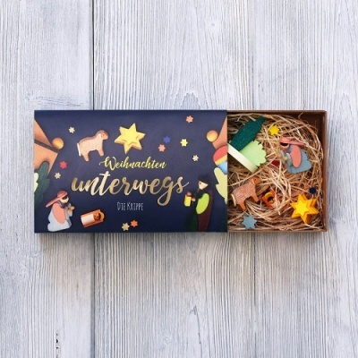 Caixa decorativa azul com figuras de madeira pintadas e cama de palha