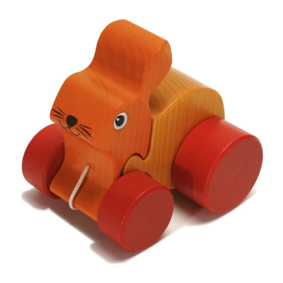 Brinquedo em madeira com formato de coelho laranja e rodas vermelhas.