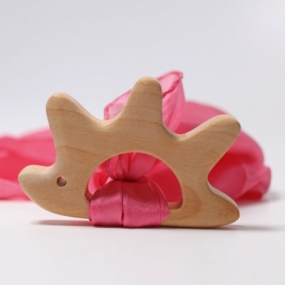 Mordedor de madeira clara em forma de dinossauro com tecido rosa
