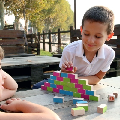 Menino a brincar com blocos de construção coloridos sobre mesa