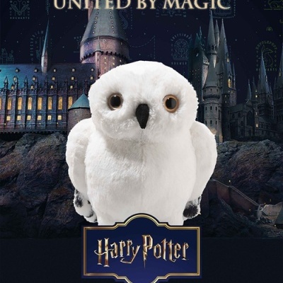 Pelúcia de coruja branca com fundo do castelo Hogwarts e texto United by Magic Harry Potter