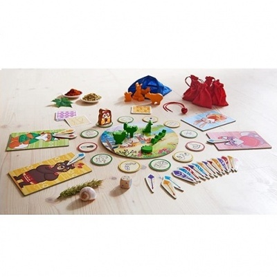 Jogo de tabuleiro com peças coloridas, cartas ilustradas e sacos de tecido