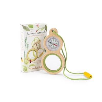 Lupa portátil de madeira com bússola e cordão verde junto à caixa ilustrada