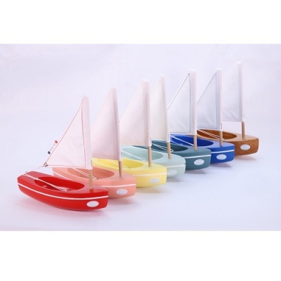 Sete barcos de brinquedo de madeira coloridos com velas brancas