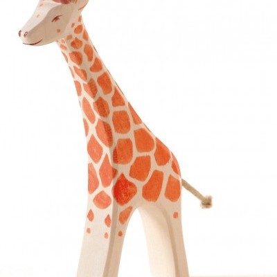 Figura de girafa de madeira pintada com padrões laranja e bege e laço cor-de-rosa no pescoço