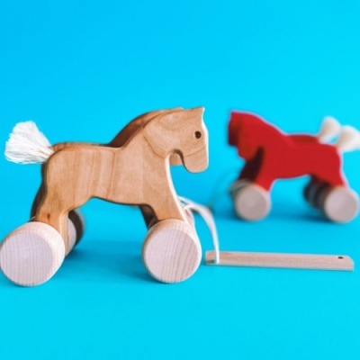 Brinquedos cavalos de madeira com rodas em fundo azul