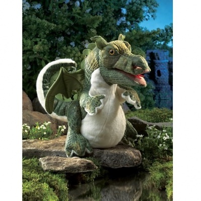 Pelúcia de dragão verde com barriga branca sobre pedras em cenário natural