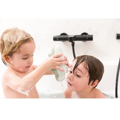 Duas crianças na banheira com esponja de banho verde e espuma