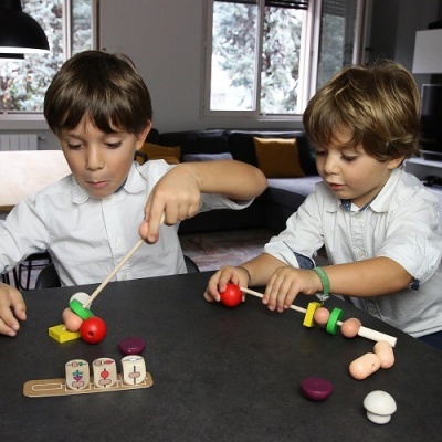 Crianças a brincar com brinquedo de madeira colorido numa mesa preta