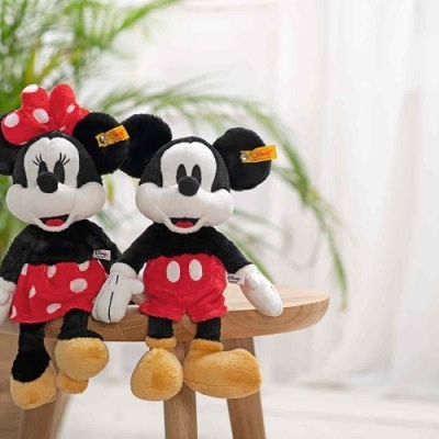 Bonecos de pelúcia do Mickey e Minnie Mouse sentados em banco de madeira