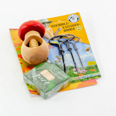 moedor de madeira com tampa vermelha, três ganchos metálicos e caixa verde de palitos, sobre embalagem amarela com texto alemão