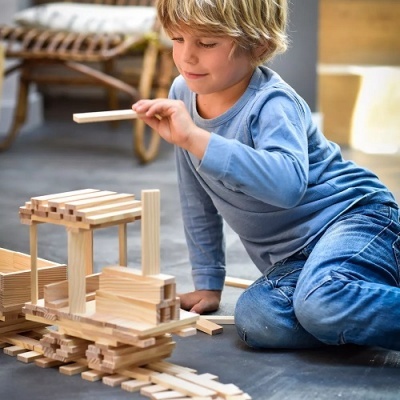 Criança a brincar com blocos de construção de madeira no chão