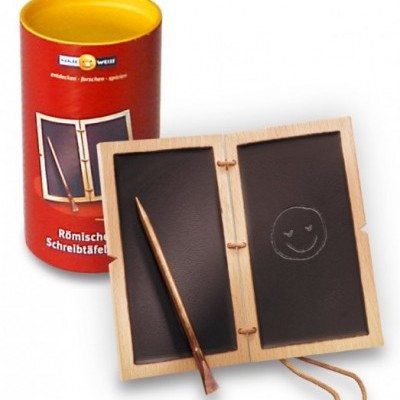 Prancha de escrita romana em madeira com duas faces pretas e embalagem cilíndrica vermelha.