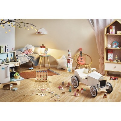 Quarto de criança com brinquedos em madeira, carrinho branco clássico, guitarra cor-de-rosa e cama com cobertores cinza