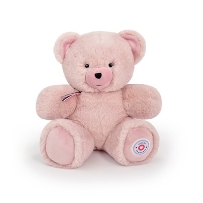 Urso de peluche cor-de-rosa sentado com laço e etiqueta na pata