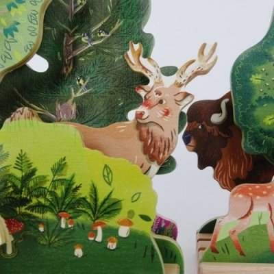Figuras recortadas de papel com ilustrações de animais da floresta e plantas verdes.