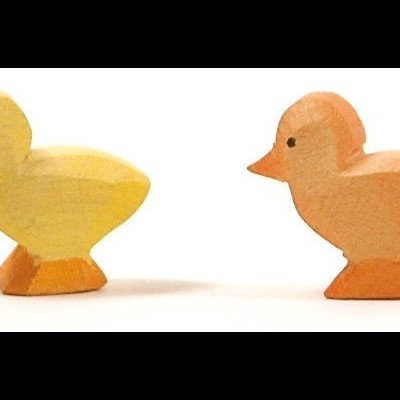 Dois patinhos de madeira amarelo e alaranjado sobre fundo branco