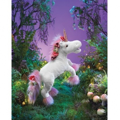 Pelúcia de unicórnio branco com crina rosa e lilás numa floresta iluminada