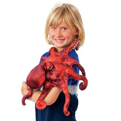 Boneco de polvo vermelho de pelúcia no braço de uma criança