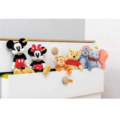 Seis peluches infantis variados sobre uma gaveta branca