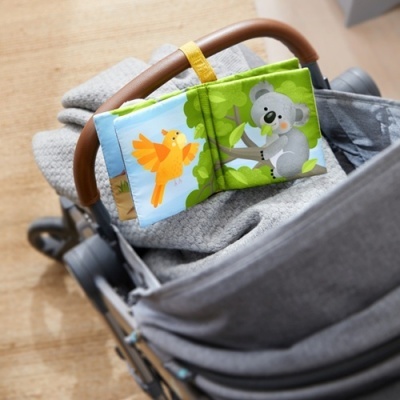 Livro de tecido infantil colorido com ilustrações de passarinho e coala no carrinho de bebé