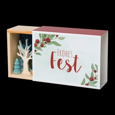 Caixa decorativa de madeira com texto 'FROHES Fest' e figuras de árvores