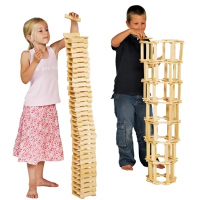 Duas crianças a construir altas torres com blocos de madeira