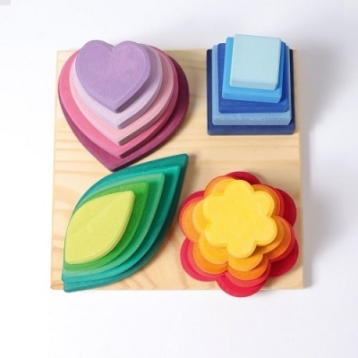 Brinquedos de madeira empilháveis em formas coloridas sobre base de madeira