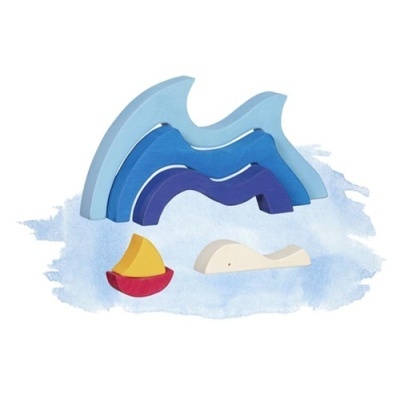 Peças de madeira coloridas representando ondas, barco e baleia sobre fundo aquarelado azul