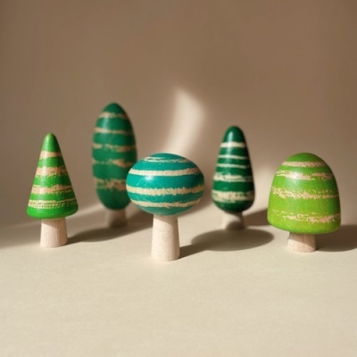 Cinco mini árvores de madeira verdes com riscas brancas e troncos em madeira natural