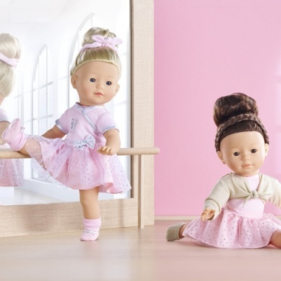 Duas bonecas de ballet com vestidos cor de rosa e cabelo apanhado, com cenário rosa e chão de madeira.