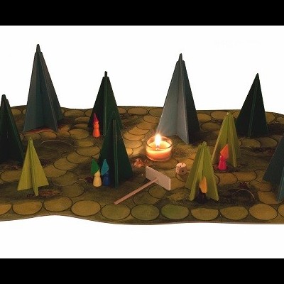 Miniaturas de árvores cónicas coloridas numa base decorativa com vela e lareira