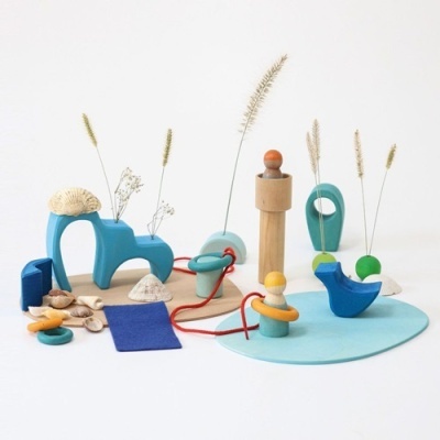 Brinquedos de madeira colorida com ramos secos em fundo branco