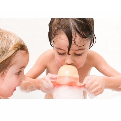 Crianças a tomar banho, uma bebé a beber de um biberão rosa com espuma