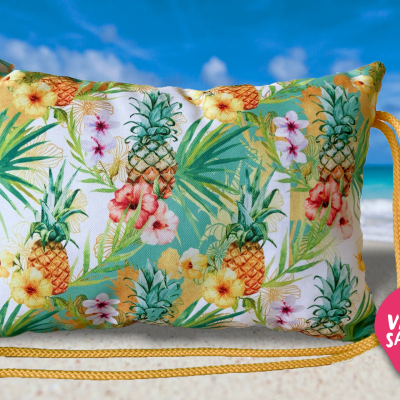 Travesseiro com padrão tropical de abacaxis e flores numa praia