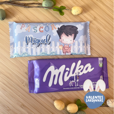 Embalagens decorativas azul claro e roxa Milka com ovinhos de Páscoa sobre superfície de madeira clara