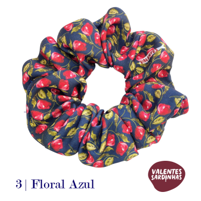 Scrunchie vermelho e verde em tecido azul com padrão floral e etiqueta VALENTES