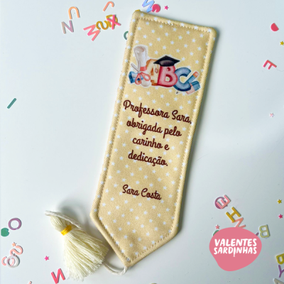 Marcador de livro amarelo com estrelas brancas, texto de agradecimento e tassel branco