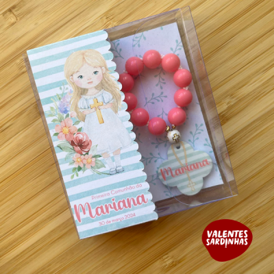 Caixa transparente com pulseira rosa e cartão decorativo para primeira comunhão